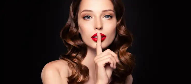  well-dressed woman making a "shhhhhh" sign